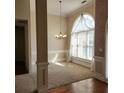 Sunlit dining room with elegant chandelier, wainscoting, and large arched window at 5035 Harbor Ridge Dr, Buford, GA 30518