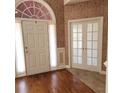 Welcoming foyer featuring hardwood floors, double doors, and an arched transom window at 5035 Harbor Ridge Dr, Buford, GA 30518