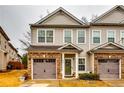 Well-maintained townhouses with attached garages, neat landscaping, and neutral siding in a residential neighborhood at 7750 Carnegie Dr, Fairburn, GA 30213