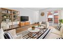 Bright living room featuring hardwood floors, striped rug, modern furniture, and balcony access at 383 Ralph Mcgill Ne Blvd # J, Atlanta, GA 30312