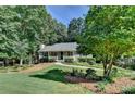 Landscaped front yard with mature trees and a winding walkway to the charming home at 1990 Holly Cove Rd, Cumming, GA 30040