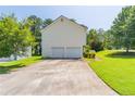 Spacious driveway leading to a two-car garage with a well-maintained lawn and landscaping at 2325 Sailor Ln, Suwanee, GA 30024