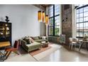 Bright living room featuring an exposed brick wall, large windows, and stylish lighting fixtures at 170 Boulevard Se # 221E, Atlanta, GA 30312