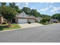 A well-manicured front lawn of a brick townhome with attached garage sitting on a tree-lined street at 2521 Eden Ridge Ln # 7, Acworth, GA 30101