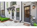 Townhome exterior featuring inviting entryways, manicured landscaping, and walkway at 12 Becker Nw Pl, Atlanta, GA 30307