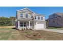 Two-story home with a manicured lawn, two car garage, and beautiful stone and brickwork at 209 Chiswick Loop, Stockbridge, GA 30281