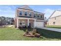 Beautiful two-story brick home with a manicured front yard and attached two-car garage at 209 Chiswick Loop, Stockbridge, GA 30281