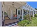 Close-up of a cozy porch with a seating area, welcome decor, lattice, and manicured landscaping at 3131 Lee Cir, Buford, GA 30518