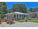 Lovely single-story home with a welcoming front porch, American flag, lush greenery, and a bench at 3131 Lee Cir, Buford, GA 30518