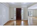 Bright entryway with hardwood floors, coat closet, and an elegant dark wood front door at 1956 Regents Way, Marietta, GA 30062