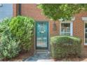 Close up of townhome entrance with charming turquoise front door, flowered wreath, and brick facade at 4177 Elder Ln, Duluth, GA 30096