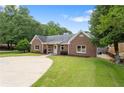 Attractive brick home with a circular driveway, lush lawn and manicured landscaping at 3690 Lithia Way, Lithia Springs, GA 30122