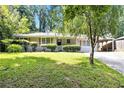 Charming ranch-style home with a well-manicured lawn and mature trees offering shade and curb appeal at 4095 Indian Creek Cir, Stone Mountain, GA 30083