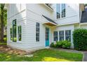 Home featuring a bright turquoise front door, complemented by lush green grass at 5271 Oglethorpe Ct, Powder Springs, GA 30127