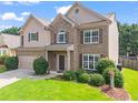 Beautiful two-story home with lush green lawn, mature landscaping, and a two-car garage on a sunny day at 1786 Jameson Cir, Lawrenceville, GA 30043