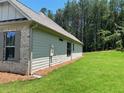 Side exterior of home with green lawn and lush forest background at 354 Brooke View Trail, Canton, GA 30115