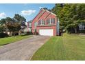 View of the exterior of a brick home with a two car garage, green lawn and driveway at 3272 Monarch Pine Dr, Peachtree Corners, GA 30071