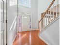 Bright foyer featuring hardwood floors, staircase with wood railing, and a decorative front door at 3272 Monarch Pine Dr, Peachtree Corners, GA 30071