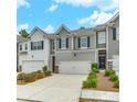 Charming townhome with gray and white siding, a two car garage and great curb appeal at 738 Woodstock Grove Dr, Woodstock, GA 30188