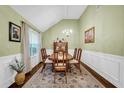 Spacious dining room with wainscoting, tall ceilings, hardwood floors, and decorative rug at 191 Baywood Way, Hiram, GA 30141