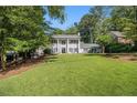 Traditional home with a lush green lawn and mature trees providing ample shade at 6300 Blackwater Trl, Atlanta, GA 30328