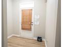 Inviting entryway featuring wood-look flooring, white trim, and a door with window and wooden blinds at 3176 Creston Park Ct, Duluth, GA 30096
