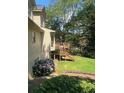 Inviting backyard featuring a wooden deck, lush greenery, and beautiful flowering bushes for outdoor enjoyment at 160 Eastlake Nw Pt, Kennesaw, GA 30144