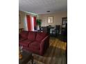 Cozy living room with hardwood floors, dining table, and a comfortable burgundy sofa at 22 Fairview Dr, Jonesboro, GA 30238