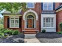 Elegant brick home entrance with arched doorway and decorative front door at 6010 Somerset Ct, Suwanee, GA 30024