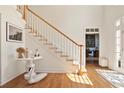 Bright entryway features hardwood floors and elegant staircase with white risers at 12160 Oak Hollow Way, Alpharetta, GA 30005