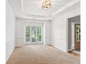 Formal dining room with tray ceiling, large window, and neutral carpet at 2720 Stillwater Lake Ln, Marietta, GA 30066