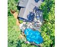 Aerial view of a private home with a backyard pool and patio area surrounded by lush trees at 4393 Cannon Rd, Loganville, GA 30052