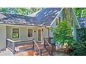 Home with an inviting entrance featuring a stone chimney and covered front porch and wood staircase at 4393 Cannon Rd, Loganville, GA 30052