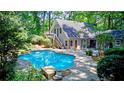 Backyard with in-ground pool surrounded by a concrete patio and landscaped garden at 4393 Cannon Rd, Loganville, GA 30052
