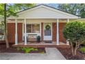 A cozy covered brick front porch with seating and decorative wreath welcomes visitors at 2703 Carolyn Se Dr, Smyrna, GA 30080
