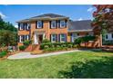 Inviting two-story brick home with lush lawn and colorful landscaping at 5004 Haralson Sw Way, Lilburn, GA 30047