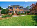 Classic brick residence with a green lawn and meticulously groomed garden at 5004 Haralson Sw Way, Lilburn, GA 30047