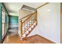 Entryway with hardwood flooring, wood staircase and decorative trim, leading to a room with teal wallpaper at 5419 Ahyoka Dr, Morrow, GA 30260