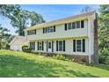 Two-story home with black shutters and a brick chimney and a simple, landscaped front yard at 5419 Ahyoka Dr, Morrow, GA 30260