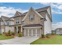 A brick two-story home featuring a two-car garage, a covered porch and landscaped lawn at 1459 Bennett Creek Ovlk, Suwanee, GA 30024