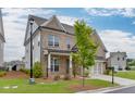 A brick two-story home with landscaped front yard, a two-car garage, and a covered porch at 1459 Bennett Creek Ovlk, Suwanee, GA 30024