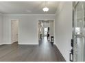 An open-concept home entrance showing the foyer with hardwood floors, crown molding, and glass front door at 1459 Bennett Creek Ovlk, Suwanee, GA 30024