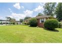 Brick home showcasing a lush green lawn and mature shrubbery in a quiet neighborhood at 2880 Sherwood Se Rd, Smyrna, GA 30082