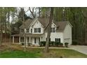 Traditional two-story home features a white exterior, black shutters and attached garage nestled among mature trees at 3618 Prescot Way, Douglasville, GA 30135