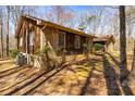 A side view of a wood and stone house featuring multiple windows and mature landscaping offers charm and privacy at 166 Muse Rd, Fayetteville, GA 30214