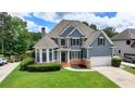 Beautiful two-story home with lush green lawn, stone accents, blue siding and an attached two-car garage at 2875 Daniel Park Run, Dacula, GA 30019