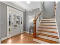 Bright foyer featuring hardwood floors, a staircase, and a charming entry door with sidelights at 1604 Gilstrap Nw Ln, Atlanta, GA 30318