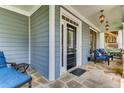 Inviting front porch with stone flooring, comfortable seating, and decorative hanging lanterns at 1604 Gilstrap Nw Ln, Atlanta, GA 30318