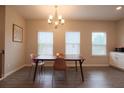 Bright dining room featuring modern chandelier, three windows, and sleek flooring at 2247 Pink Hawthorn Dr, Buford, GA 30518