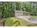 A suburban house with attached garage and long driveway surrounded by lush green trees at 3957 Evans Drive Dr, Lithia Springs, GA 30122